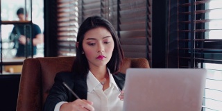 肖像亚洲美丽的女孩或妇女的手使用电脑在工作场所的业务。网上购物，转账，网上银行，快乐就是一切作为灵感概念，