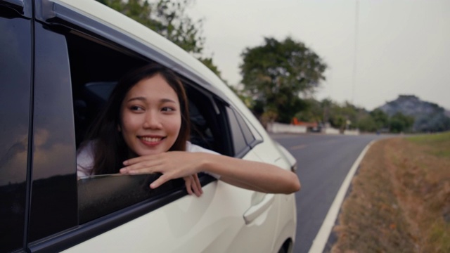 掀背车旅行驾车公路旅行的年轻女子暑假在汽车在假日日落和放松得到的气氛和去目的地。慢动作C4K电影镜头