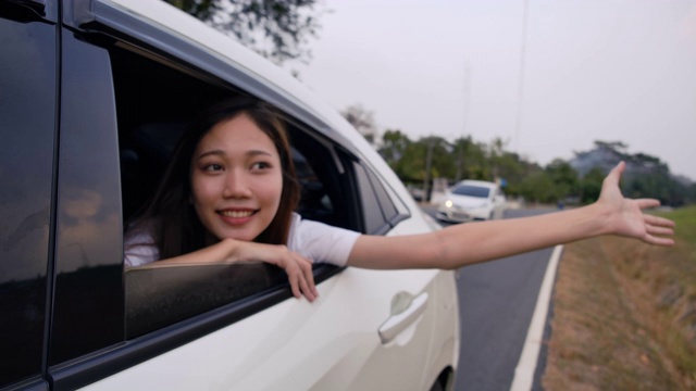 掀背车旅行驾车公路旅行的年轻女子暑假在汽车在假日日落和放松得到的气氛和去目的地。慢动作C4K电影镜头