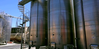 大型不锈钢葡萄酒蒸馏罐。用于葡萄酒和啤酒发酵的筒仓。酿酒厂用于发酵葡萄酒的钢桶。多莉，浪人移动一长排酒桶。