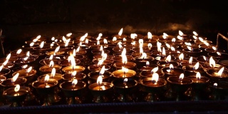 在尼泊尔加德满都的一座寺庙中点燃仪式蜡烛
