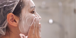 亚洲女性在浴室用泡沫水洗脸