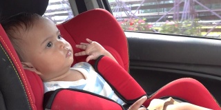 小女孩把零食放在汽车安全座椅上