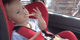 小女孩把零食放在汽车安全座椅上