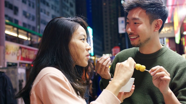 SLO MO近距离拍摄一对年轻夫妇吃街头小吃