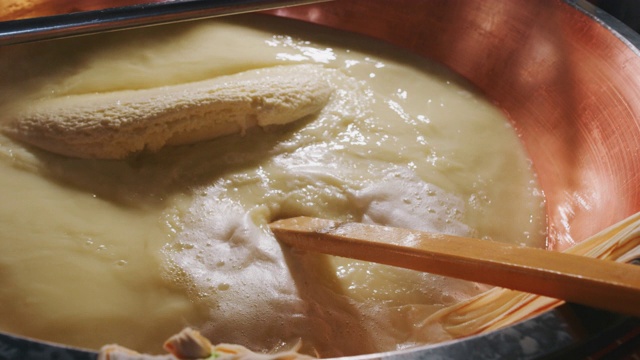 慢镜头近距离拍摄的一个奶酪制作者正在准备一种形式的帕尔玛奶酪使用新鲜和生物牛奶遵循古老的意大利传统