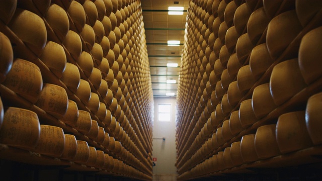 慢动作滑块的观点，许多车轮帕尔马干酪是成熟的古老的意大利传统仓库货架上好几个月