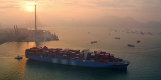 鸟瞰图集装箱货轮在码头商埠整箱集装箱向海上移动的业务物流，进出口，海运或运输