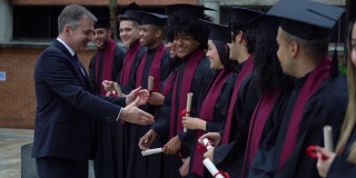自豪的大学院长和每一位拿着毕业证书的毕业生握手