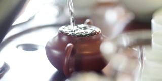 用手把热水从茶壶里倒出来。