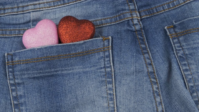 全景。两个象征性的心形从牛仔裤后口袋里伸出来，特写。情人节。
