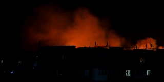 乌克兰，夜色中的城市，映衬着一座房子的剪影。火灾灾难和事故悲剧概念。