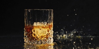 冰块落入威士忌杯中，以慢动作溅起水花。