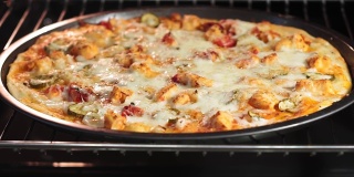 用电热对流烤箱烹饪披萨。将披萨放在冷却器内的热烤盘上。鸡肉黄瓜和奶酪的披萨