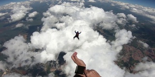 跳伞者带着云从飞机上跳下来