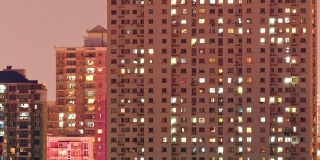 上海公寓楼白天到晚上的过渡时间流逝。中国拥挤的城市，夜晚灯火通明。在城市的大都市中，4k的时间间隔。