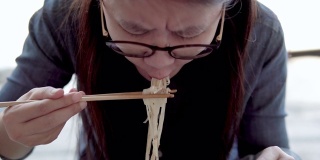 吃面条的亚洲女人。
