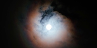 月亮在夜空中随云的时间流逝。