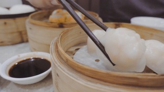 在香港的餐馆里，用筷子从蒸煮锅里拿热虾和酱汁视频素材模板下载