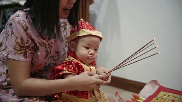 妈妈抱着儿子向神龛祈求好运