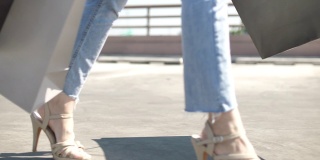 Close up of woman's legs with shopping bags