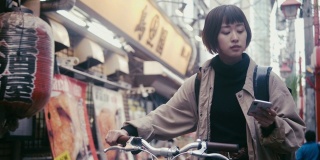 日本女食品快递员在东京寻找送货地址(慢镜头)