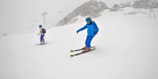 母亲和儿子在阿尔卑斯山的冰川上滑雪