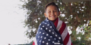 骄傲的西班牙男孩被美国星条旗包裹的肖像