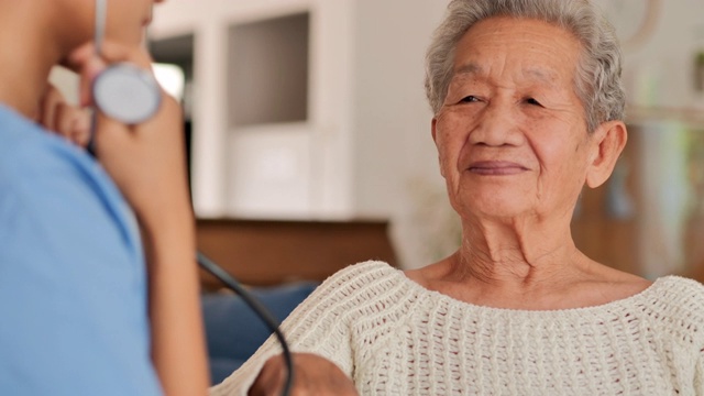 年轻黑人女护士医生为亚洲老年妇女检查心脏，以预防冠状病毒或Covid-19在家里流行。医疗:护理、教育、医疗、护理、志愿者、养老院、冠状病毒或新冠病毒