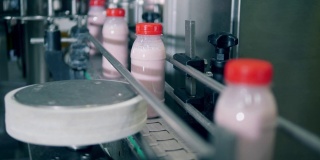 塑料瓶和酸奶在工厂的生产线上。