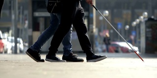 帮助盲人。一名男子帮助盲人在城市中行走