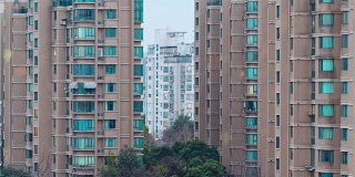 上海公寓楼白天到晚上的过渡时间流逝。中国拥挤的城市，夜晚灯火通明。在城市的大都市中，4k的时间间隔。