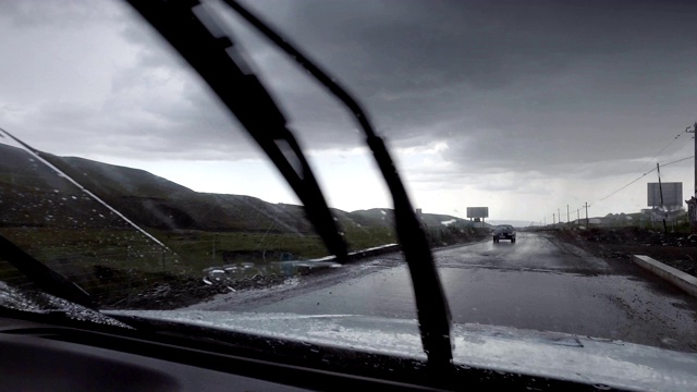 汽车在雨天行驶在山路上，新疆，中国。