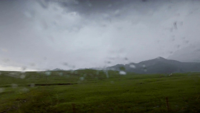 汽车在雨天行驶在山路上，新疆，中国。