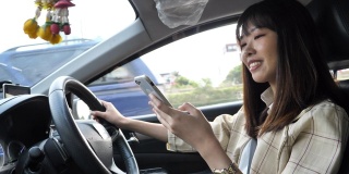 亚洲女商人驾驶一辆装有智能手机的汽车