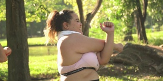 女性大体型运动员伸展她的手臂在一个公共公园