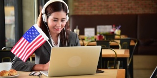 商业女性看在线体育笔记本电脑和欢呼美国挥舞美国国旗。