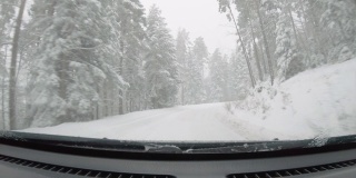 汽车POV在积雪覆盖的路上行驶，先下起了雪。