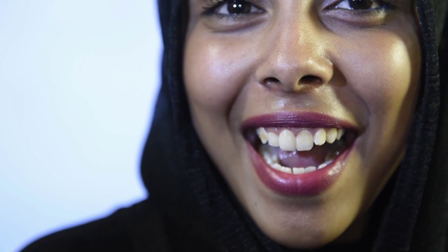 Close portrait of young Muslim girl face looking at camera in hijab