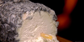这是一个圣马ure de Touraine山羊奶酪的特写，稻草在中间