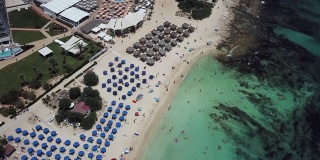 无人机拍摄的风景如画的尼斯沙滩在塞浦路斯，清澈的绿松石水和岩石底部