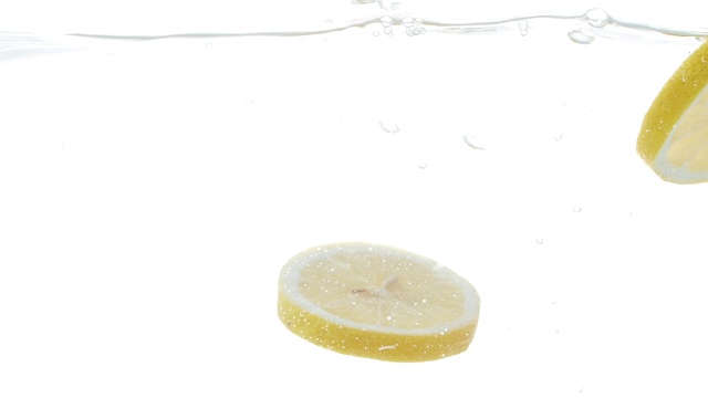切片柠檬落入水中的慢动作视频