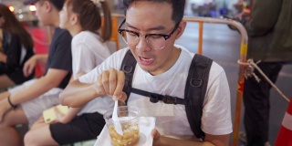 男子吃泰式甜点，软豆腐在热姜糖浆在当地街头小吃