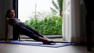 亚洲女性以苗条的身材在家练习瑜伽，积极健康的生活方式理念视频素材模板下载