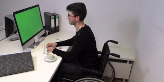 一个坐在轮椅上的经理，一个不能在他工作的电脑前行走的年轻人，慢动作