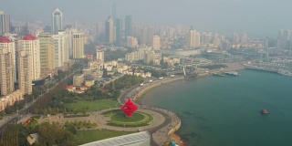 阳光灿烂的日落青岛市区著名的海湾广场航拍全景4k中国