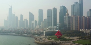 阳光灿烂的日落青岛市区著名的海湾红纪念碑广场航拍全景4k中国
