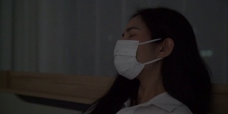 年轻女子咳嗽，脸上戴着口罩