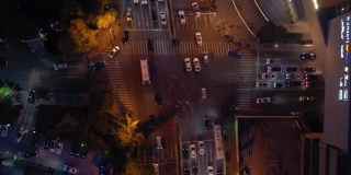 黄昏夜晚，照亮了青岛市区交通街道十字路口高空俯视图4k中国