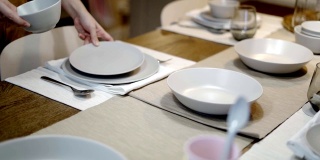 在餐厅里，把精致的餐桌上的盘子和刀叉清空